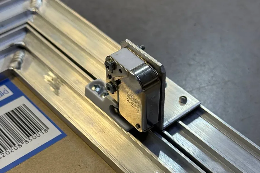 Натискний замок Hafele Mini Latch на рамі ревізійного люка ProfiLuki